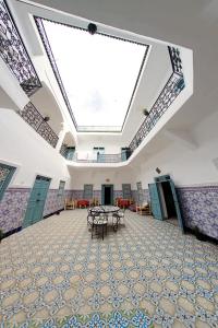 a large room with a large ceiling with tables and chairs at Hostel BE 20 in Marrakech