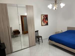 a bedroom with a blue bed and a mirror at Le Scalette in Castelvecchio Subequo