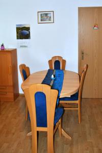 une table à manger avec des chaises et un chiffon bleu dans l'établissement Riverside Village Apartment, à Bohinj