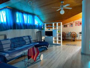 Mansarda seaview في سينِغاليا: غرفة معيشة مع أريكة ومروحة سقف