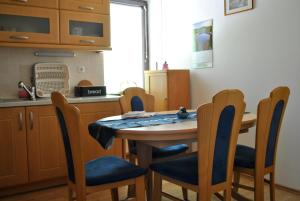 - une cuisine avec une table en bois, des chaises, une table et un comptoir dans l'établissement Riverside Village Apartment, à Bohinj