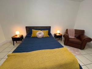 a bedroom with a bed and a couch and a chair at Spacious Studio - minutes from MIA airport in Miami