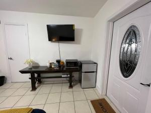 een kamer met een tafel en een televisie aan de muur bij Spacious Studio - minutes from MIA airport in Miami