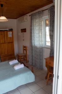 a bedroom with a bed and a desk and a window at Vaso Alykanas Studios in Alikanas