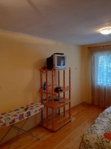 een kamer met een tv op een plank en een bed bij Къща за гости Дани in Govedartsi