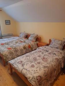 two beds sitting next to each other in a bedroom at Къща за гости Дани in Govedartsi
