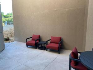 drie rode stoelen en een tafel op een patio bij The Resort at Lake of the Ozarks in Lake Ozark