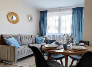 a living room with a couch and a table at Apartamenty Przy Wydmie Dębina in Debina