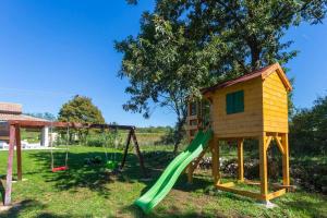 een speeltuin met een huis en een glijbaan bij Modern House with private pool in Žminj
