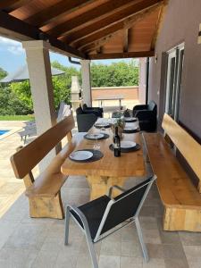 una mesa de madera y sillas en un patio en Modern House with private pool, en Žminj