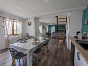 eine Küche und ein Esszimmer mit einem Tisch und Stühlen in der Unterkunft Gîte La Rive Gauche in Saint-Même-les-Carrières