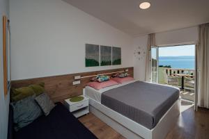 a bedroom with a bed and a view of the ocean at Apartments Tina in Brela