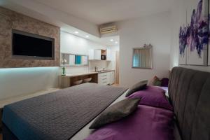 ein Schlafzimmer mit einem großen Bett und einem Waschbecken in der Unterkunft Apartments Tina in Brela
