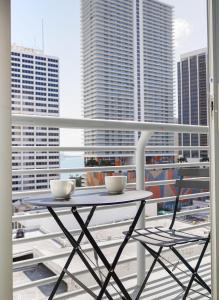 a table and chairs on a balcony with buildings at Center Stage- Downtown Parking Pool Hot Tub in Miami
