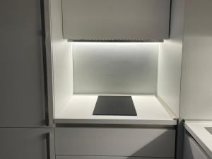 an empty refrigerator with a light in a kitchen at La Finestra sul Mare Modern Apartment in Giardini Naxos