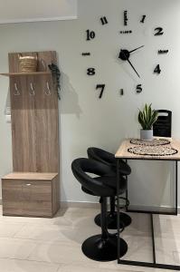 a desk with a chair and a clock on a wall at Agapi’s apartment in Thessaloniki