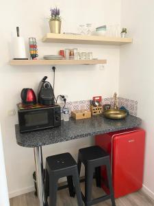 a kitchen with a counter with a microwave and a sink at Paris Jolie studio cosy in Paris