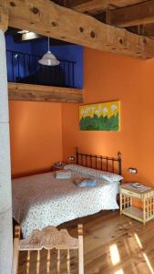 Montoro de Mezquita的住宿－Casa rural Vallore del Maestrazgo，一间卧室设有一张床和橙色的墙壁