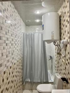 a bathroom with a shower and a toilet at Olympia in Gudauta