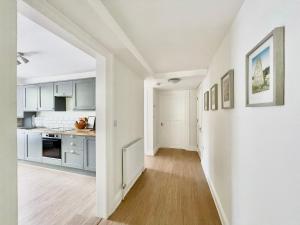 a kitchen with white cabinets and a hard wood floor at Lincombe Court Apartment Wellswood Torquay in Torquay +12 photos