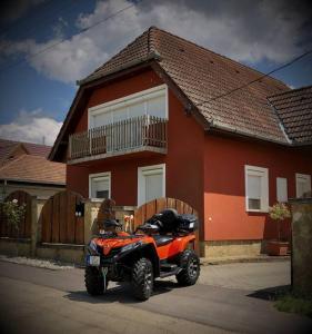 un vehículo de cuatro ruedas estacionado frente a una casa en Zsuzsi Vendégház Visz en Visz