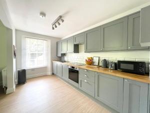 a kitchen with gray cabinets and a counter top at Lincombe Court Apartment Wellswood Torquay in Torquay