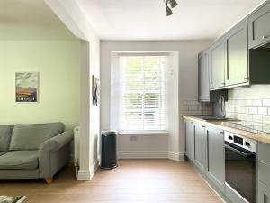 a kitchen with a couch and a window in a room at Lincombe Court Apartment Wellswood Torquay in Torquay
