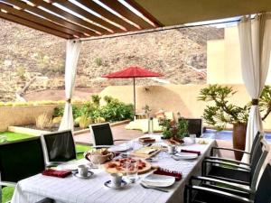 a table with a white table cloth on a patio at Precioso chalet en Santa Cruz con piscina in Santa Cruz de Tenerife