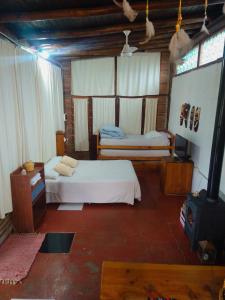 a bedroom with two beds and a stove in it at Cabaña en Villa General Belgrano in Villa General Belgrano
