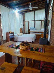 a room with two beds and a table in it at Cabaña en Villa General Belgrano in Villa General Belgrano