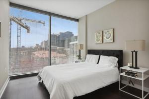 1 dormitorio con cama blanca y ventana grande en Piedmont Park 2 bdrm, en Atlanta