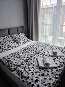 een bed met twee handdoeken en een raam bij Silver 58 Zator in Zator