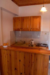 uma cozinha com armários de madeira e uma bancada em Vaso Alykanas Studios em Alikanas