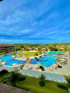 an aerial view of a resort pool with umbrellas at MARENOSTRUM -VISTA MAR - PRAIA DOS CARNEIROS - ECO RESORT- 2 Suítes in Praia dos Carneiros