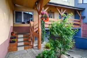 a house with a porch with flowers on it at Apartamenty Mieszka I in Łódź