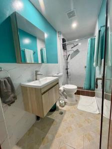 a bathroom with a sink and a toilet at Ngermid Oasis-Spacious Studio Loft W/ Garden Views in Koror