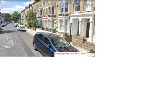 um carro azul estacionado ao lado de uma rua em Stunning 1 bedroom apartment in London em Londres
