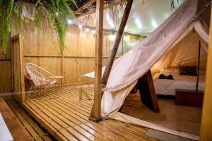 Seren Glamping في أوفيتا: غرفة نوم بسرير وأرجوحة على أرضية خشبية