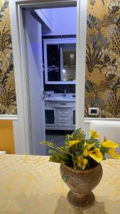 波佐利的住宿－Elina’s Puteoli House，一张花瓶,上面有黄色的花朵,坐在桌子上