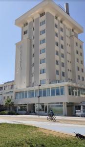 a person riding a bike in front of a building at Hotel Golden in Rimini