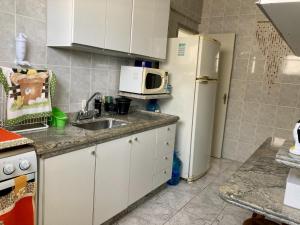 a kitchen with a white refrigerator and a sink at Apto frente mar na melhor localização de Praia Grande in Praia Grande +8 photos
