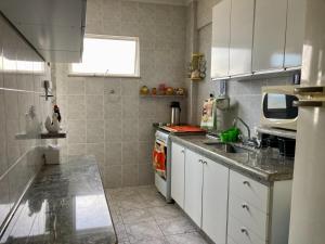 a kitchen with a sink and a counter top at Apto frente mar na melhor localização de Praia Grande in Praia Grande