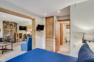 a bedroom with a blue bed and a living room at Laurelwood Condominiums 405 in Snowmass Village