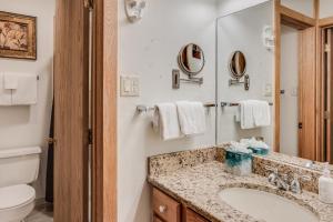 een badkamer met een wastafel, een toilet en een spiegel bij Laurelwood Condominiums 405 in Snowmass Village