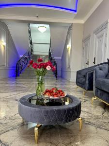 a living room with a table with a bowl of red roses at RiverRun in Sukhum