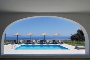 a view of a swimming pool through an archway at Villa Arco Bianco in Afantou