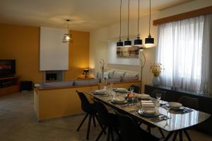 ein Esszimmer und ein Wohnzimmer mit einem Tisch und Stühlen in der Unterkunft Villa Arco Bianco in Afandou