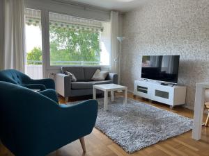 Kompakti kolmio hyvällä sijainnilla في توركو: غرفة معيشة مع أريكة وتلفزيون