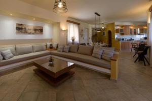un ampio soggiorno con divano e tavolo di Villa Arco Bianco a Afantou