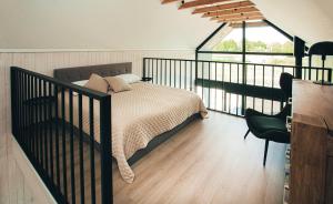 a bedroom with a bed and a balcony at WakeMālpils brīvdienu mājas in Mālpils